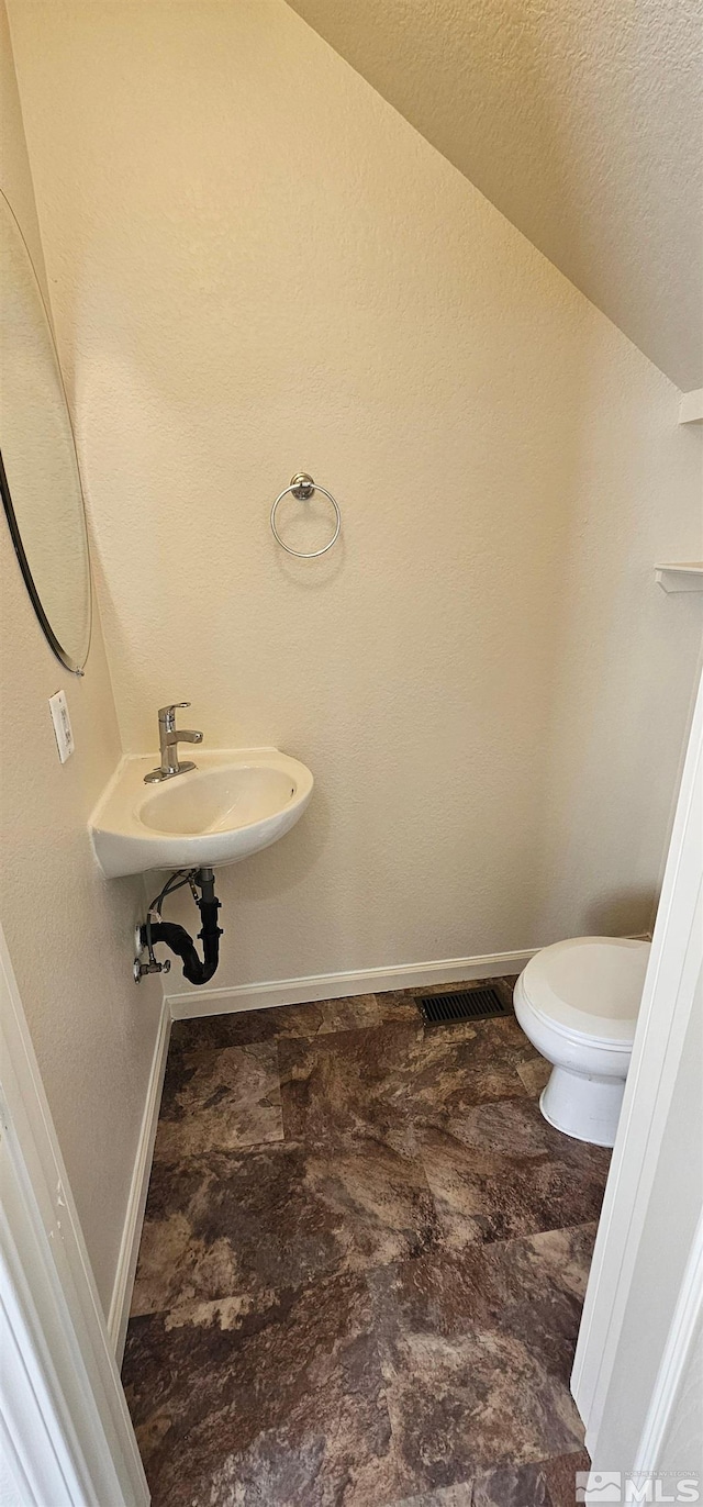 bathroom featuring baseboards, toilet, and a textured ceiling