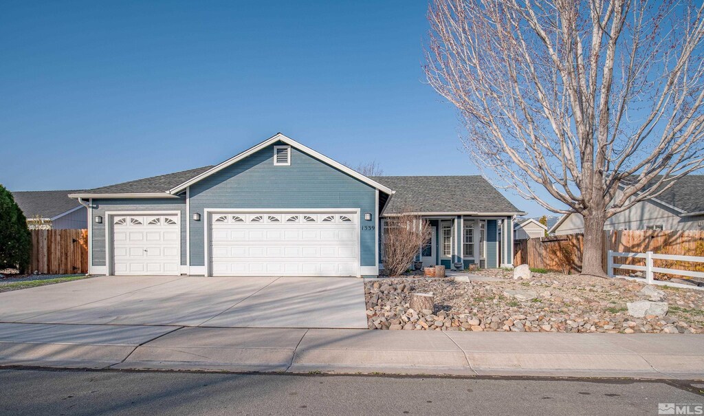 single story home with concrete driveway, a shingled roof, fence, and an attached garage