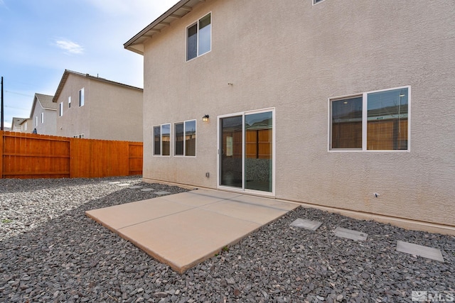 back of house with stucco siding, fence private yard, and a patio area