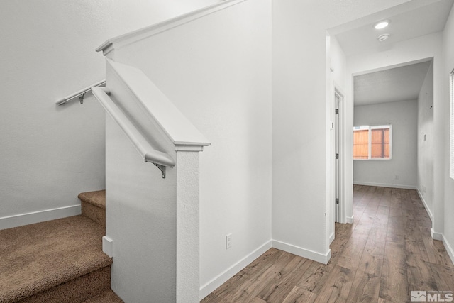 stairway with baseboards and hardwood / wood-style flooring