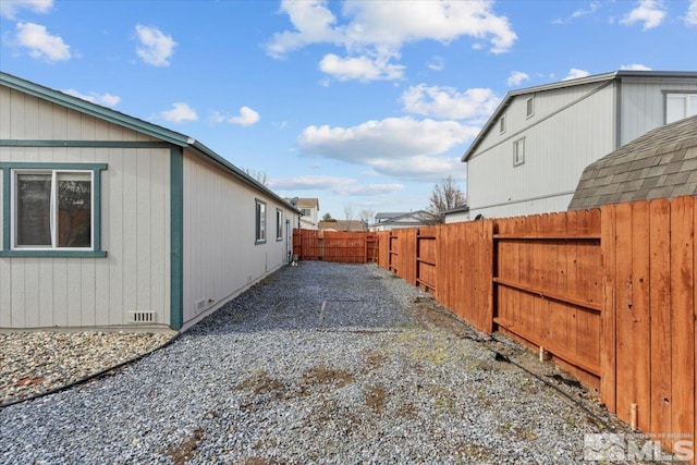 view of side of home with crawl space and fence