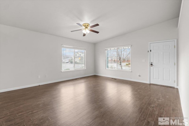 interior space with vaulted ceiling, dark wood-style flooring, baseboards, visible vents, and ceiling fan