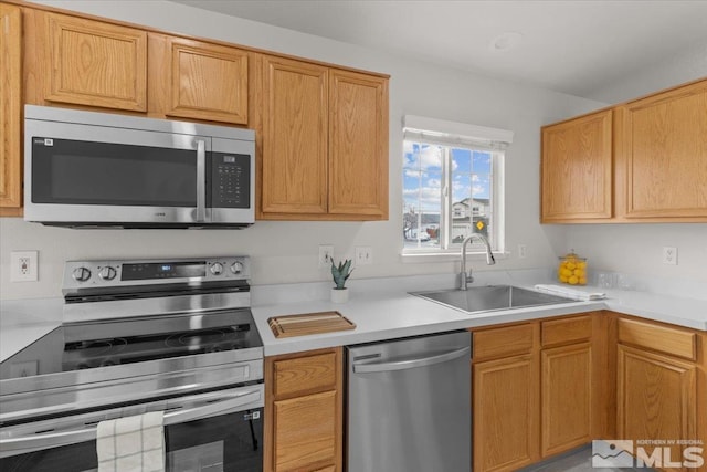 kitchen featuring light countertops, a sink, and stainless steel appliances
