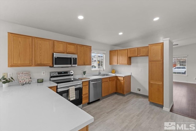 kitchen featuring light countertops, light wood-style floors, a sink, and stainless steel appliances