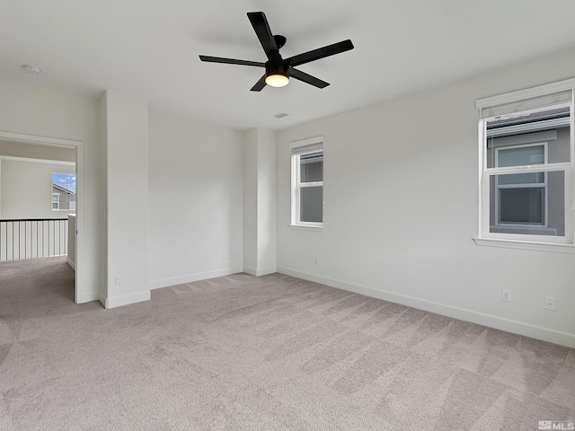 spare room with plenty of natural light, baseboards, ceiling fan, and carpet flooring