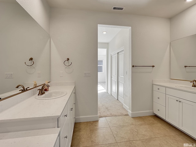 bathroom featuring visible vents, a sink, and two vanities
