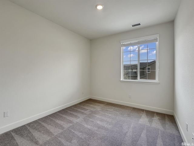 spare room with baseboards, carpet flooring, and visible vents