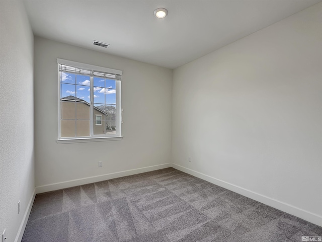 spare room featuring carpet floors, baseboards, and visible vents