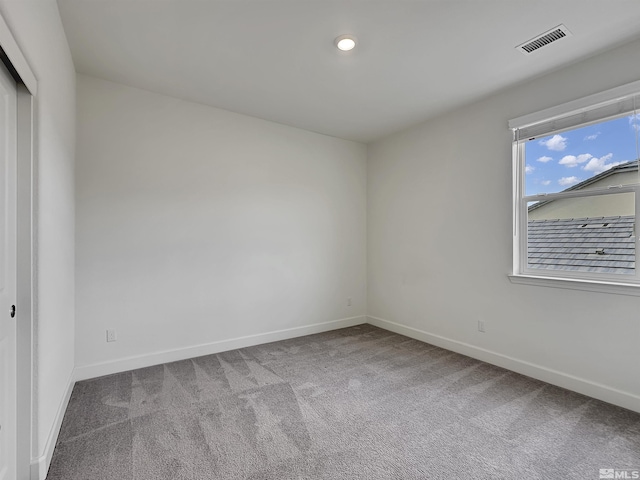 spare room featuring carpet flooring, baseboards, and visible vents