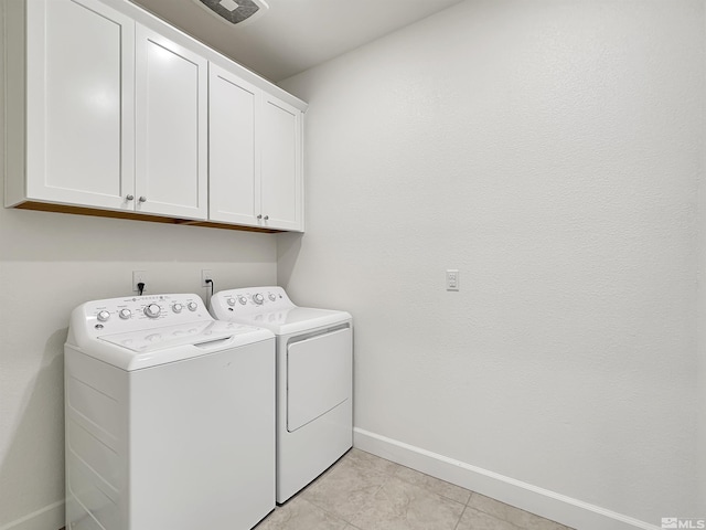 laundry room featuring light tile patterned flooring, baseboards, visible vents, washer and dryer, and cabinet space