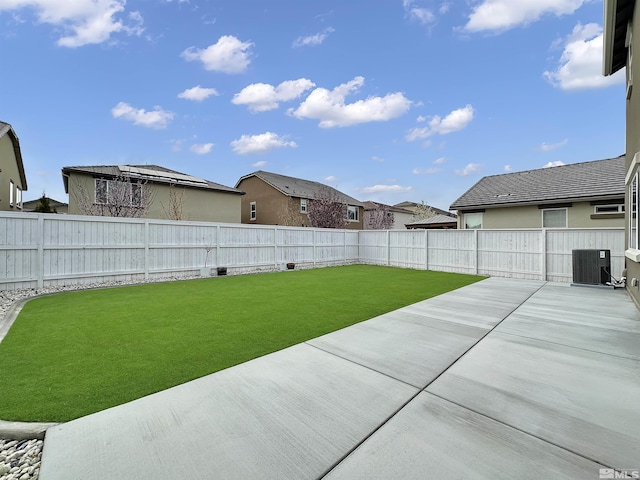 view of yard with central AC unit, a fenced backyard, and a patio area