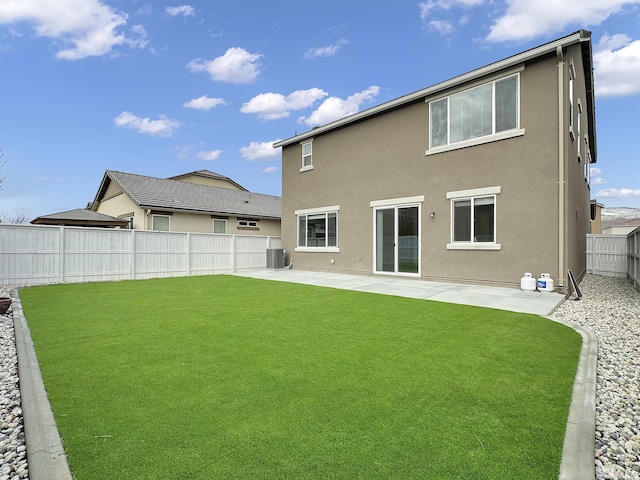 back of house with stucco siding, central air condition unit, a patio, a fenced backyard, and a lawn