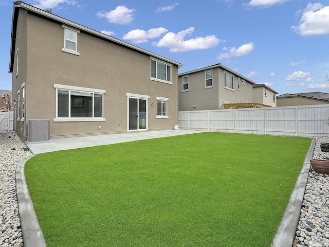 back of property with a fenced backyard, stucco siding, a patio, and a yard