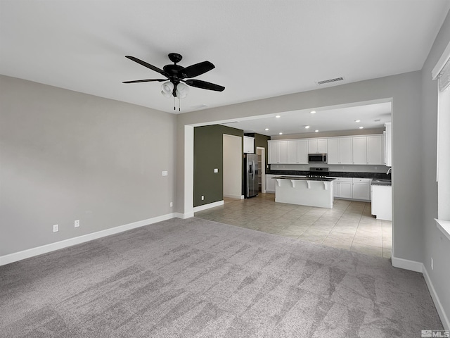 unfurnished living room with a ceiling fan, light carpet, baseboards, visible vents, and recessed lighting