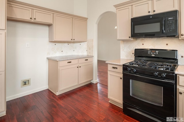 kitchen with cream cabinetry, baseboards, arched walkways, dark wood-style floors, and black appliances