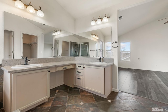 bathroom featuring vanity, a shower stall, a walk in closet, lofted ceiling, and visible vents