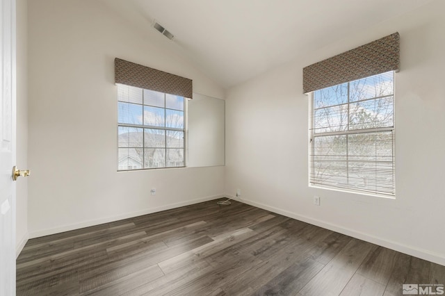 spare room featuring a wealth of natural light, lofted ceiling, baseboards, and dark wood-style flooring
