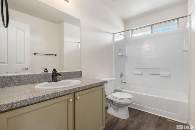 full bath featuring toilet, wood finished floors, vanity, and shower / bathtub combination