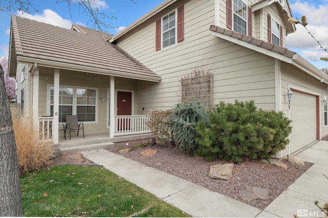 traditional-style house featuring a porch and a garage