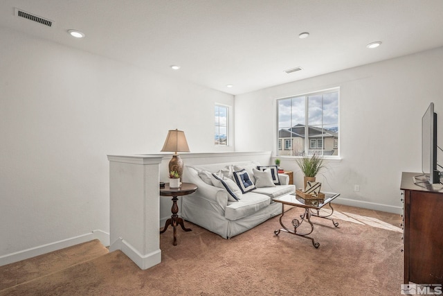 carpeted living area featuring baseboards, visible vents, and recessed lighting