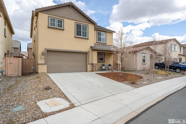 traditional-style house featuring fence, an attached garage, concrete driveway, a tile roof, and stucco siding