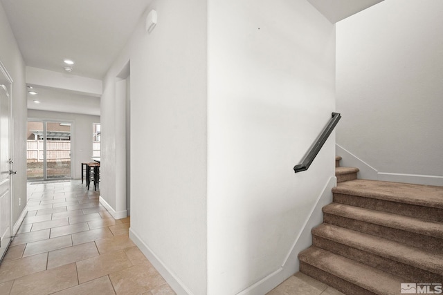 stairway featuring baseboards, tile patterned flooring, and recessed lighting