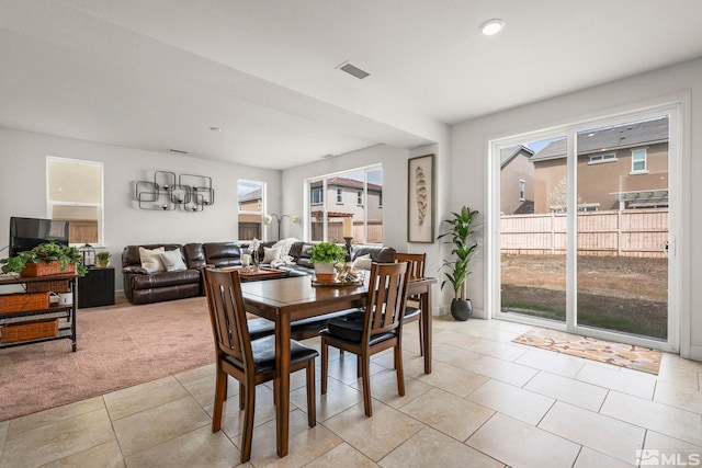 dining room featuring light colored carpet, visible vents, and light tile patterned floors