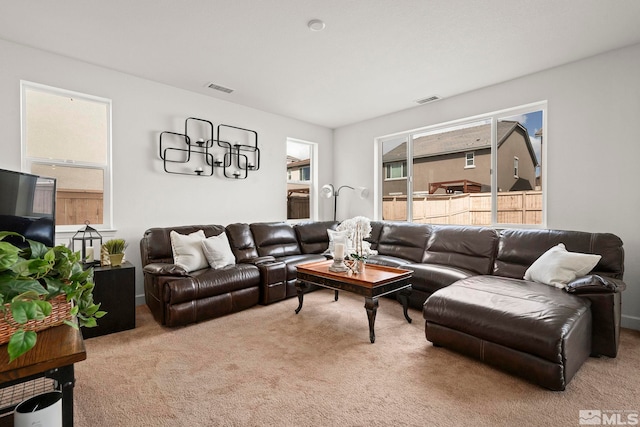 carpeted living area featuring an inviting chandelier and visible vents