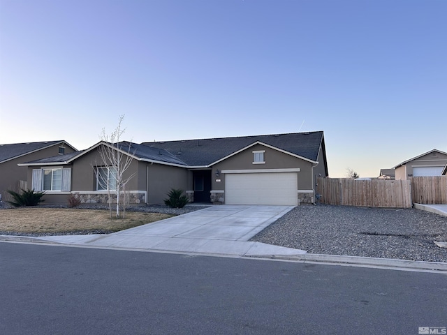 single story home with stone siding, driveway, stucco siding, and fence