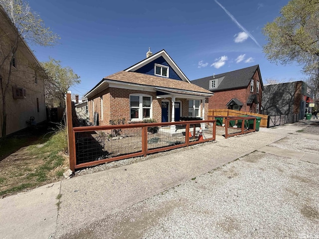 bungalow-style home with brick siding and fence