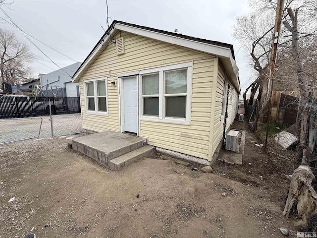 rear view of house with central air condition unit and fence