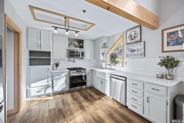 kitchen featuring open shelves, light countertops, a sink, stainless steel appliances, and backsplash