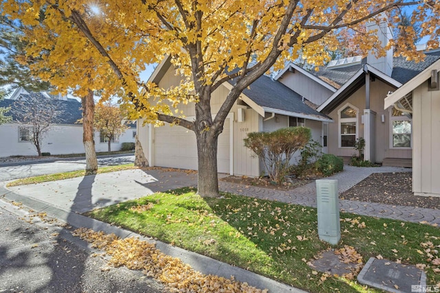 view of home's exterior with a shingled roof, a garage, and concrete driveway