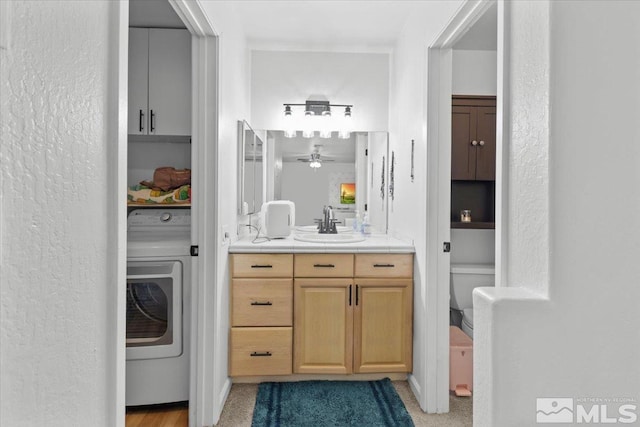 bathroom with washer / clothes dryer, vanity, and a ceiling fan