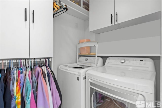 laundry room with independent washer and dryer and cabinet space