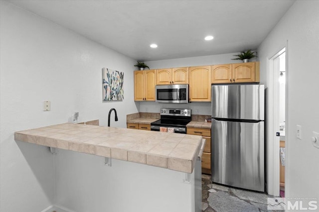 kitchen featuring recessed lighting, appliances with stainless steel finishes, a peninsula, and light brown cabinets