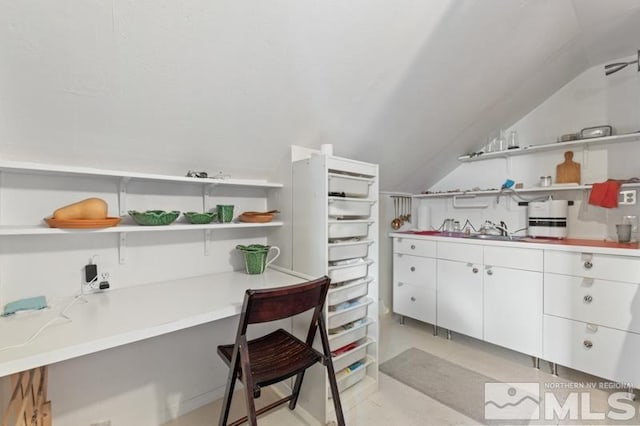 kitchen with open shelves, white cabinets, vaulted ceiling, light countertops, and a sink