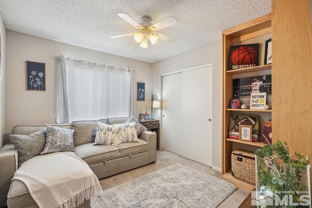 carpeted living room featuring a textured ceiling and ceiling fan