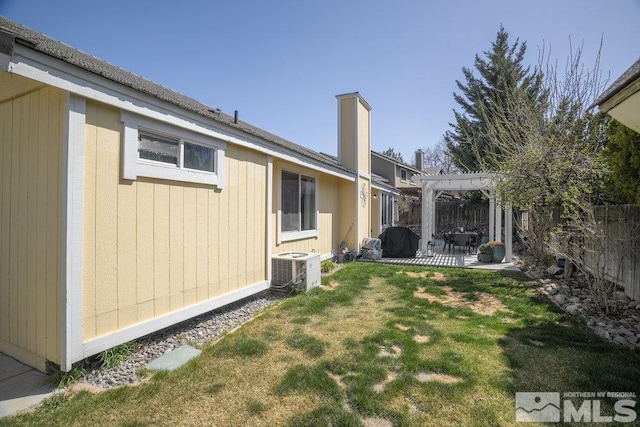 view of yard with a pergola, a fenced backyard, central AC unit, and a patio area