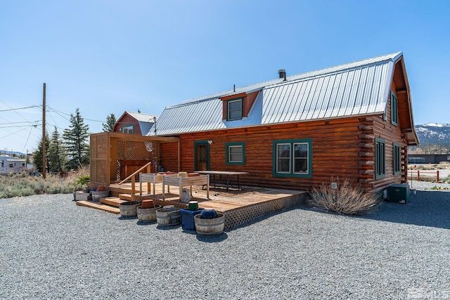 rear view of house featuring a gambrel roof, central AC, log siding, metal roof, and a deck