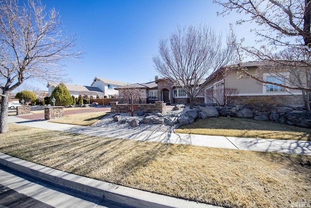 ranch-style house with a front lawn, stone siding, and stucco siding