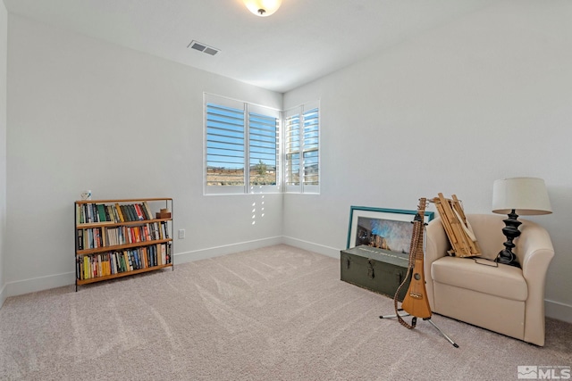 living area with visible vents, baseboards, and carpet floors