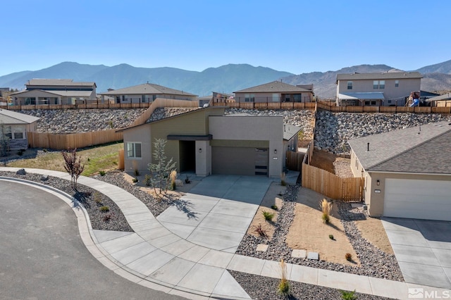 ranch-style home featuring stucco siding, a mountain view, driveway, a garage, and fence