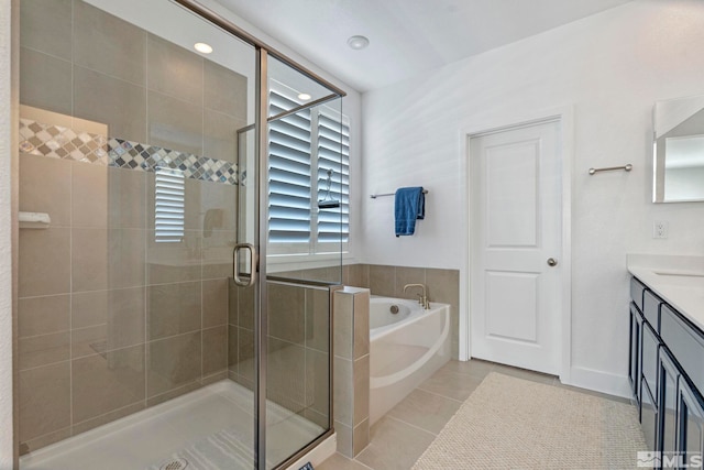 bathroom with tile patterned flooring, a shower stall, vanity, and a garden tub