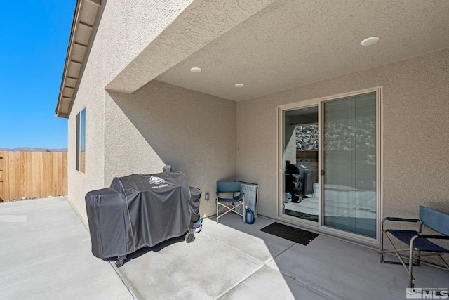 view of patio / terrace with a grill and fence