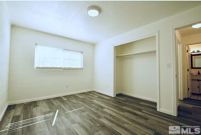 unfurnished bedroom featuring a closet, baseboards, and wood finished floors