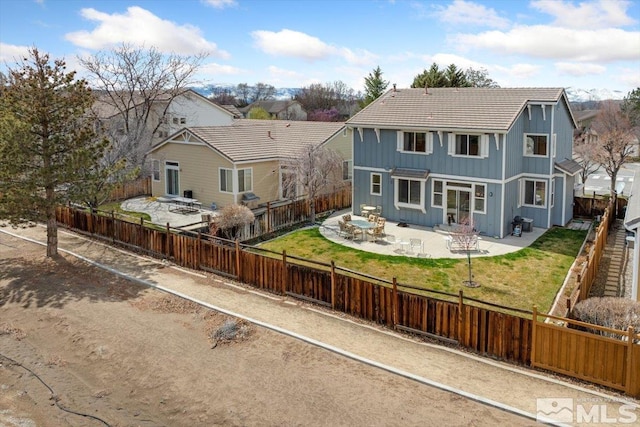 back of property with a patio, board and batten siding, a fenced backyard, a tile roof, and a lawn