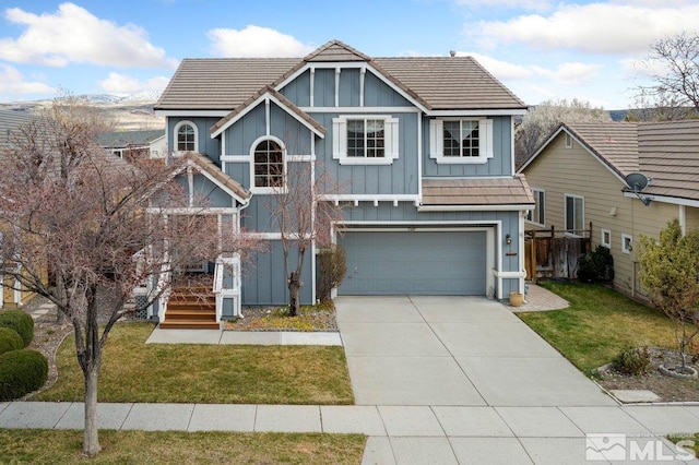 view of front of home featuring board and batten siding, a front yard, a garage, and driveway