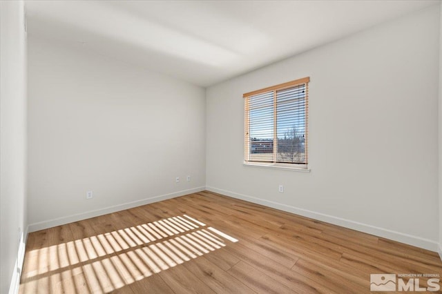 unfurnished room featuring baseboards and wood finished floors