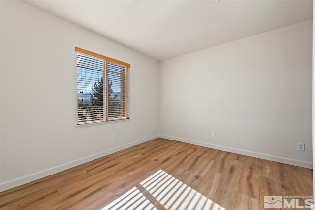 empty room featuring light wood-style flooring and baseboards